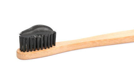 Photo of Bamboo toothbrush with charcoal paste isolated on white