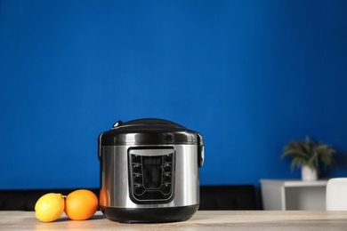 Modern multi cooker and ingredients on table indoors, space for text