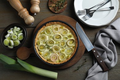 Flat lay composition with tasty leek pie and ingredients on wooden table