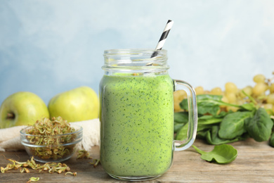 Tasty green buckwheat smoothie on wooden table