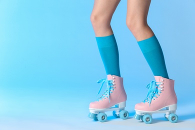 Photo of Woman with vintage roller skates on color background, closeup. Space for text