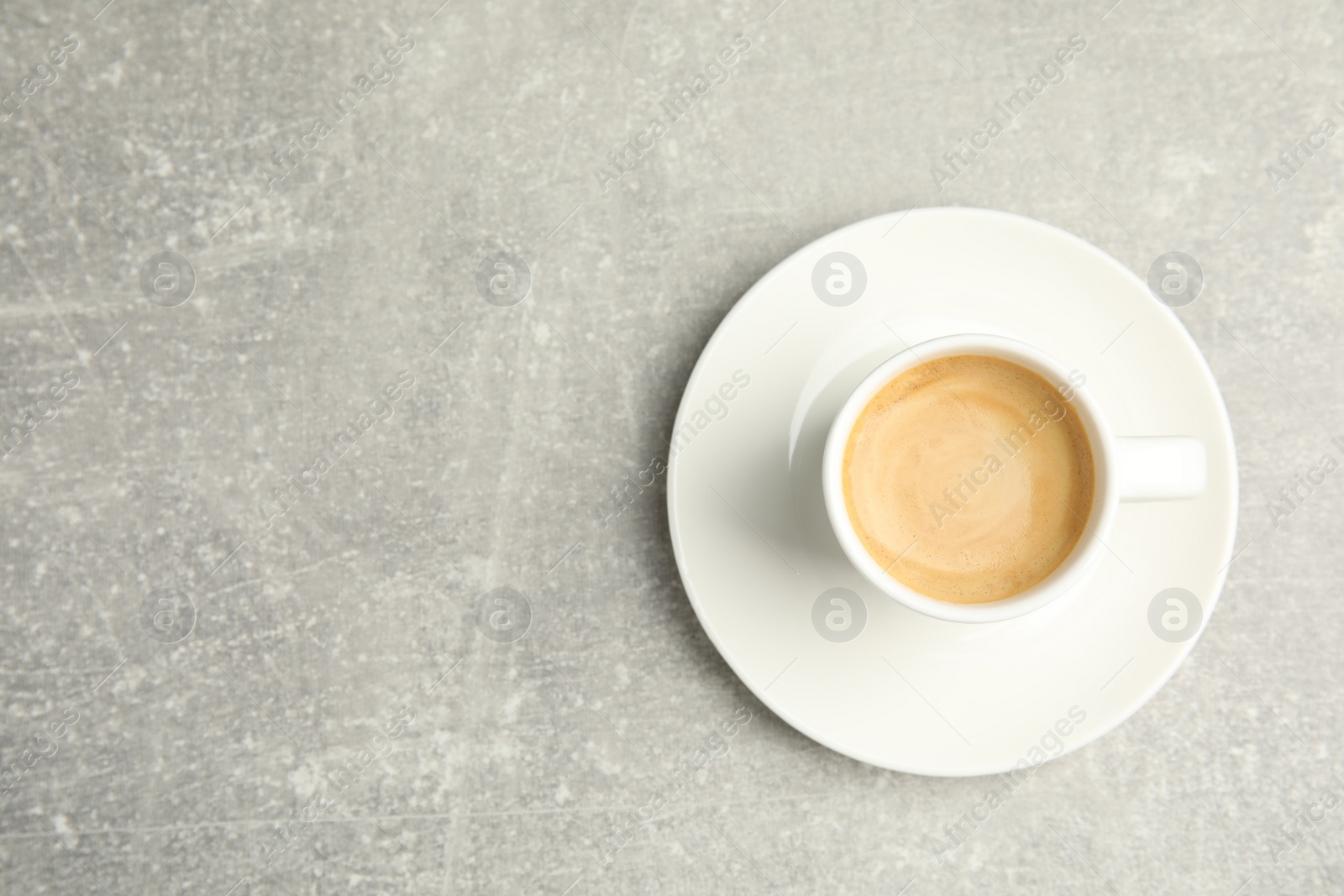 Photo of Cup of hot aromatic espresso on light table, top view. Space for text