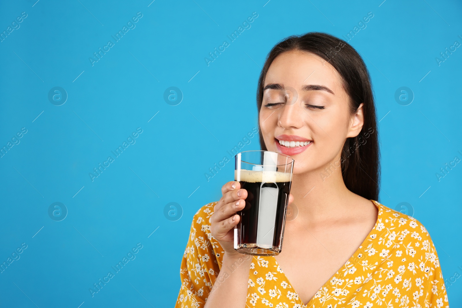 Photo of Beautiful woman with cold kvass on blue background. Traditional Russian summer drink