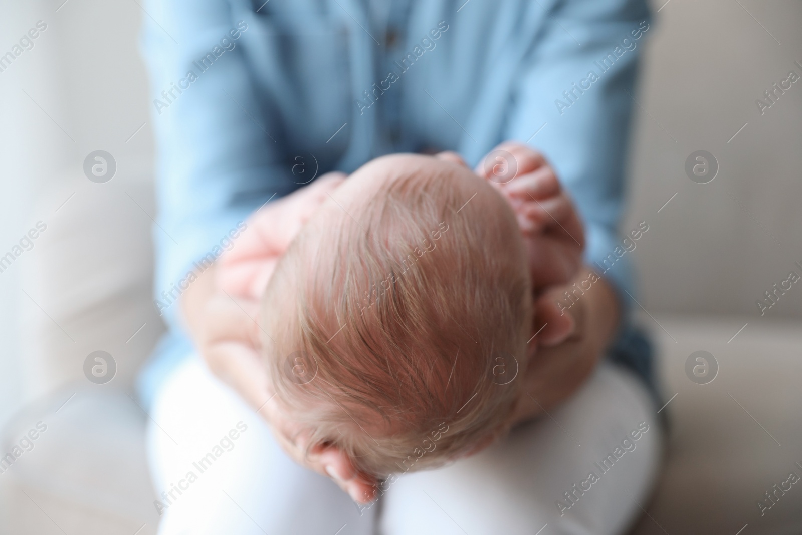 Photo of Mother holding her newborn baby at home, closeup