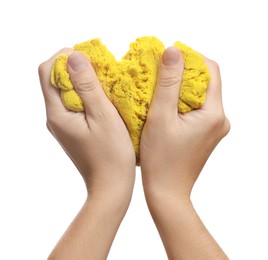 Woman playing with yellow kinetic sand on white background, closeup