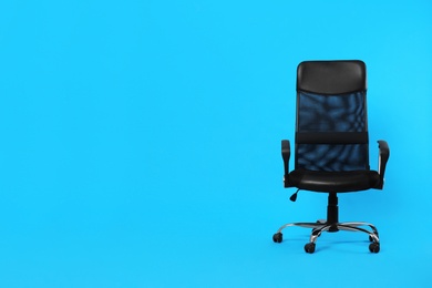 Photo of Comfortable office chair on light blue background, space for text