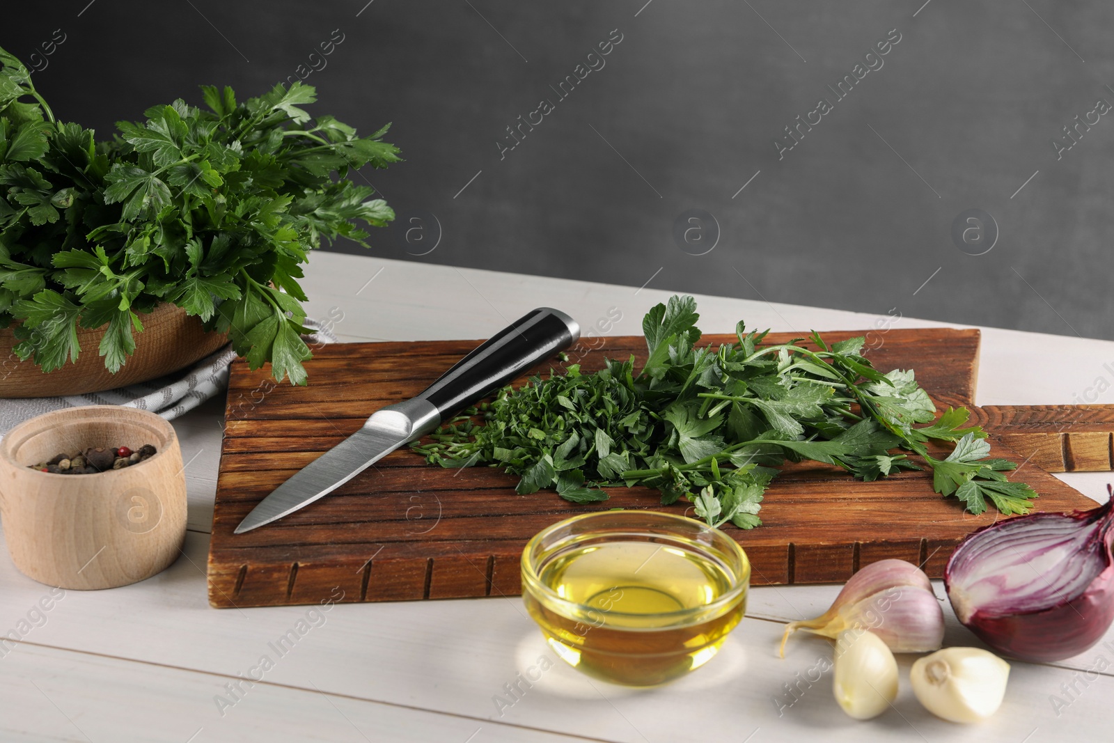 Photo of Fresh green parsley and different products on white wooden table