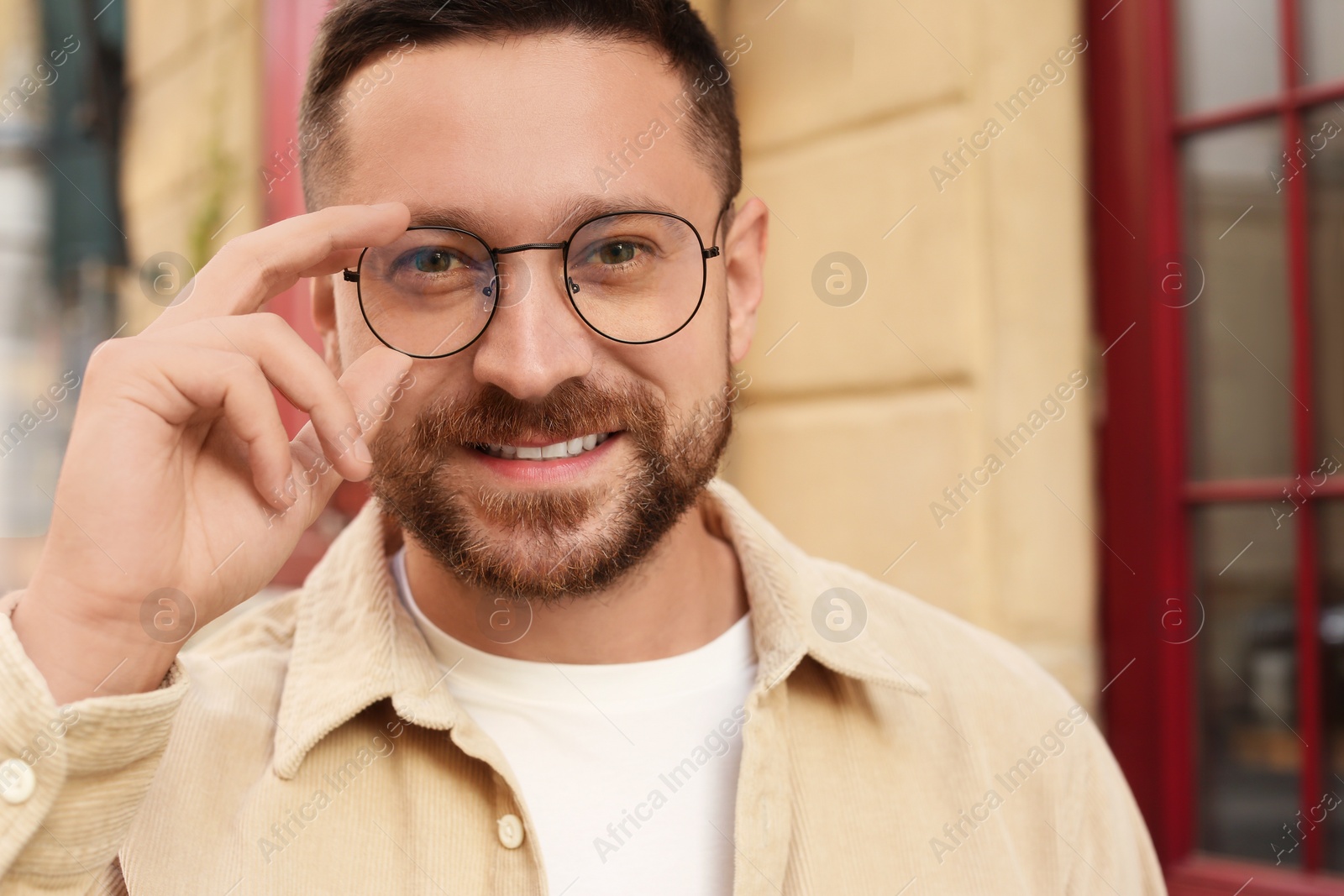 Photo of Portrait of handsome bearded man in glasses outdoors