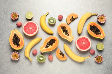 Fresh ripe papaya and other fruits on light grey table, flat lay