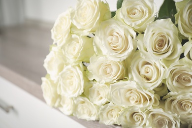 Photo of Luxury bouquet of fresh roses on commode, closeup