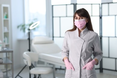 Photo of Cosmetologist in medical uniform in clinic, space for text