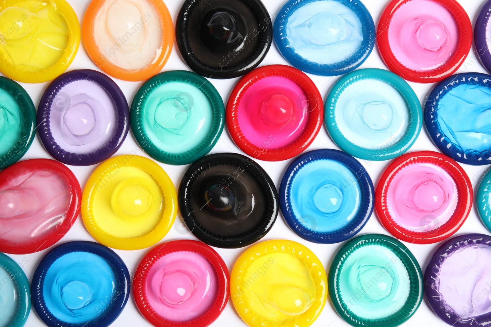 Photo of Unpacked colorful condoms on white background, top view. Safe sex