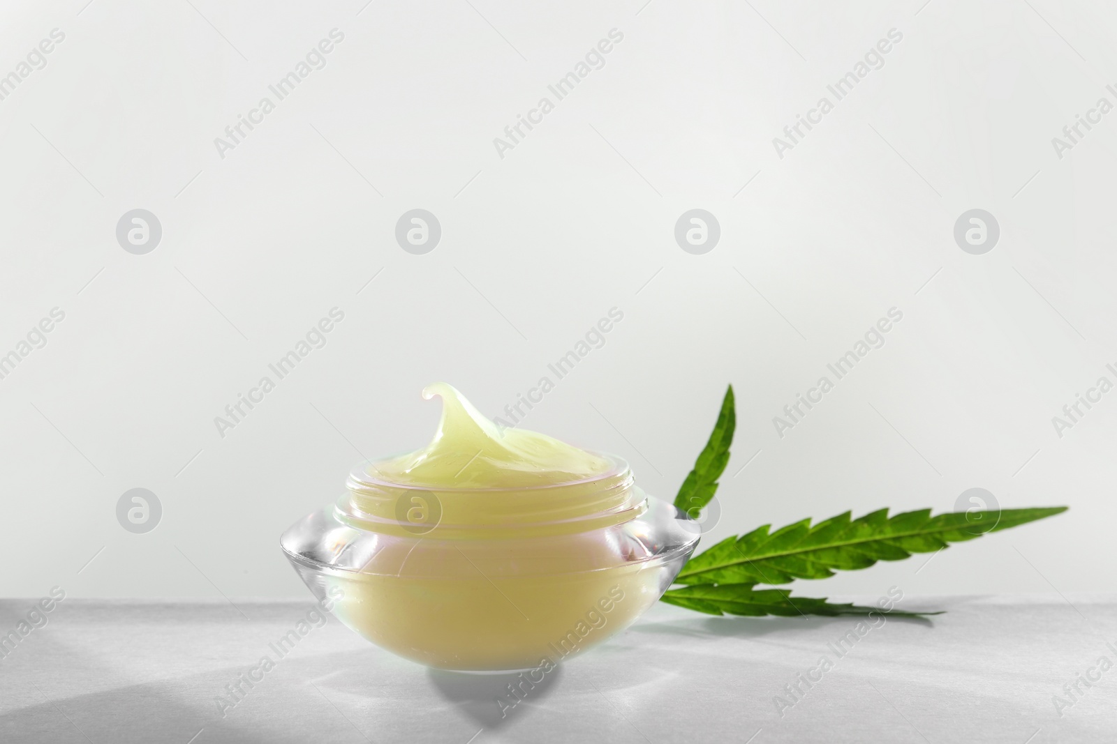 Photo of Jar with hemp lotion on white background