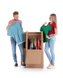 Young couple near wardrobe boxes on white background