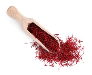 Photo of Dried saffron and wooden scoop on white background, top view