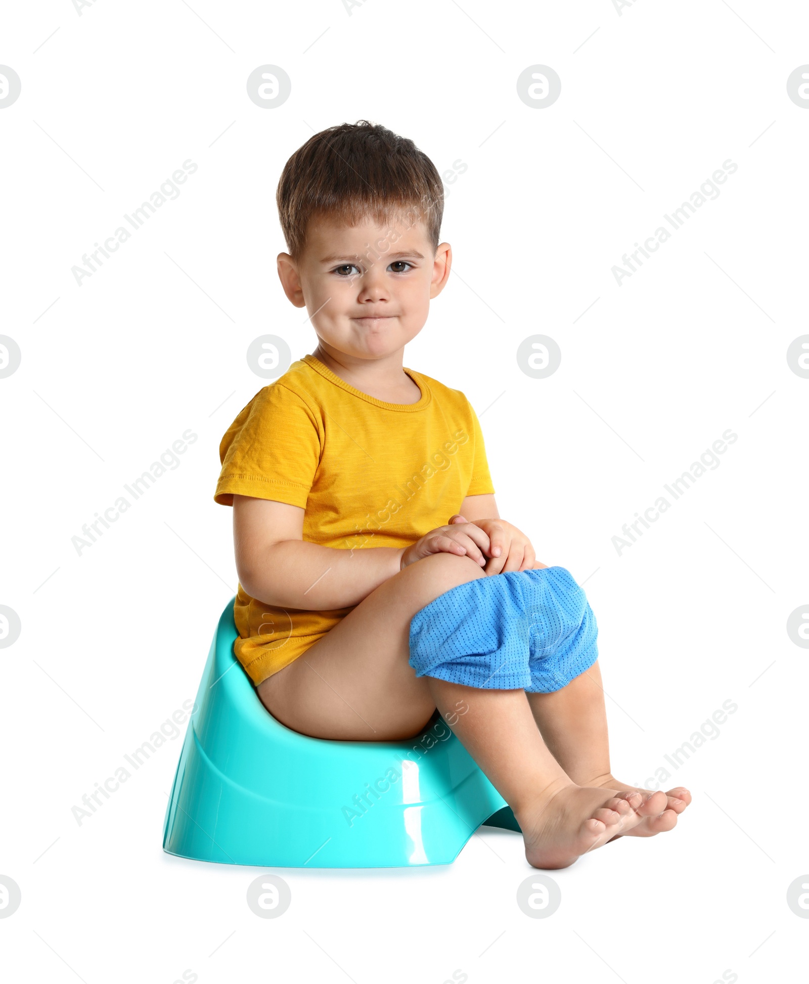 Photo of Portrait of little boy sitting on potty against white background