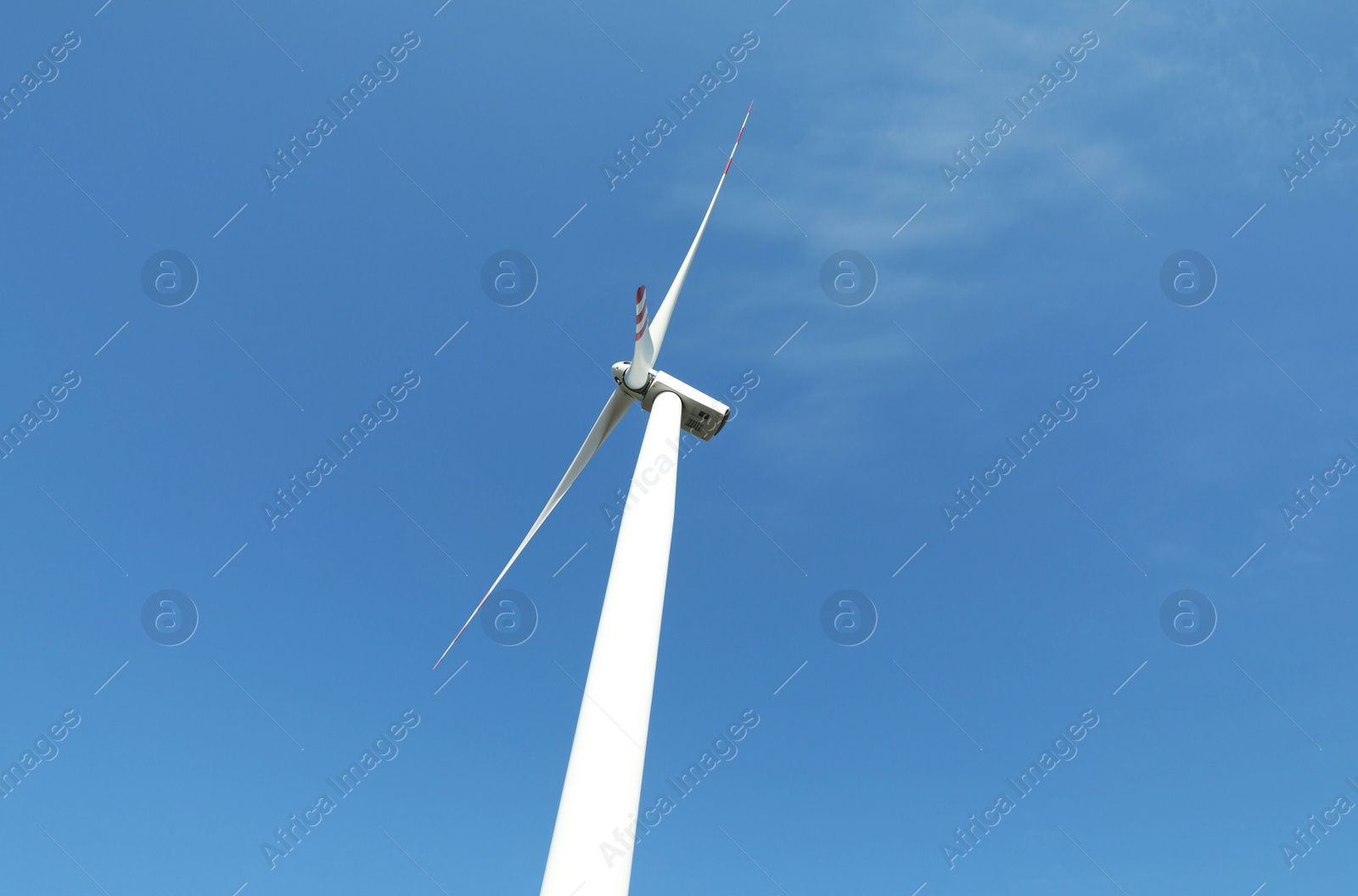 Photo of Modern wind turbine against blue sky, low angle view. Alternative energy source