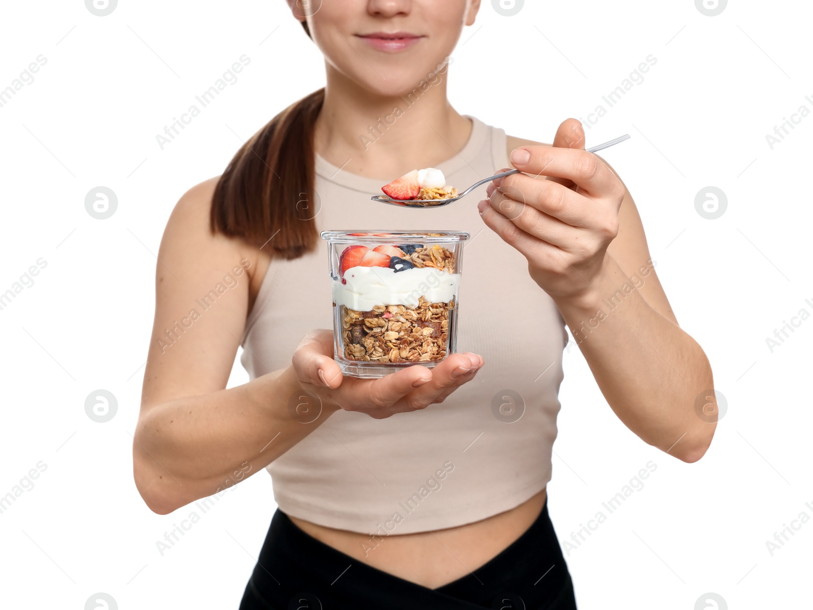 Photo of Woman eating tasty granola with fresh berries and yogurt on white background, closeup