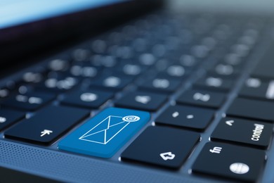 Image of Light blue button with illustration of envelope and email sign on laptop keyboard, closeup