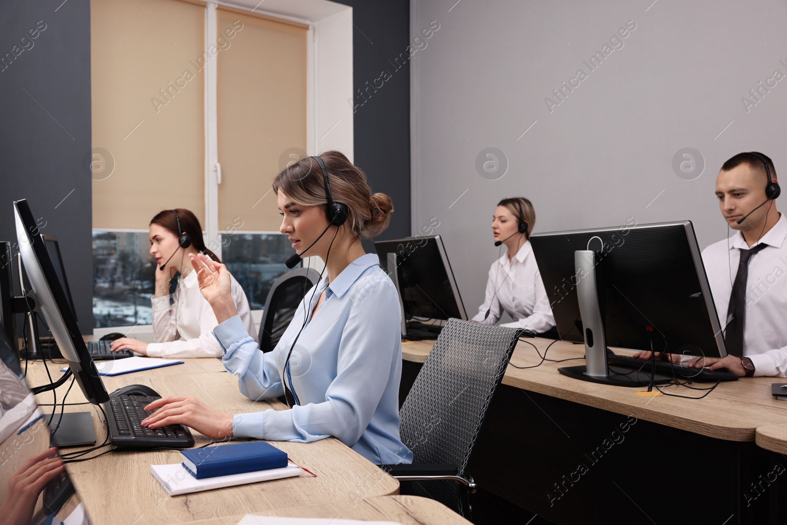 Photo of Call center operators with headsets working in modern office