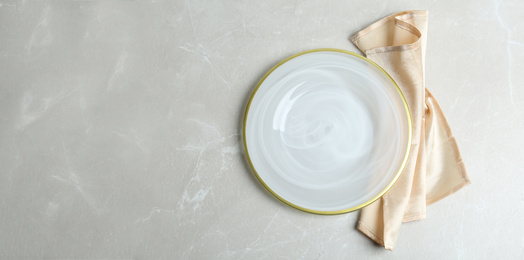 Photo of Empty plate and napkin on light grey marble table, flat lay