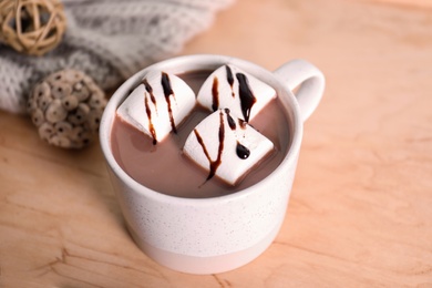 Photo of Cup of aromatic cacao with marshmallows on wooden table, closeup