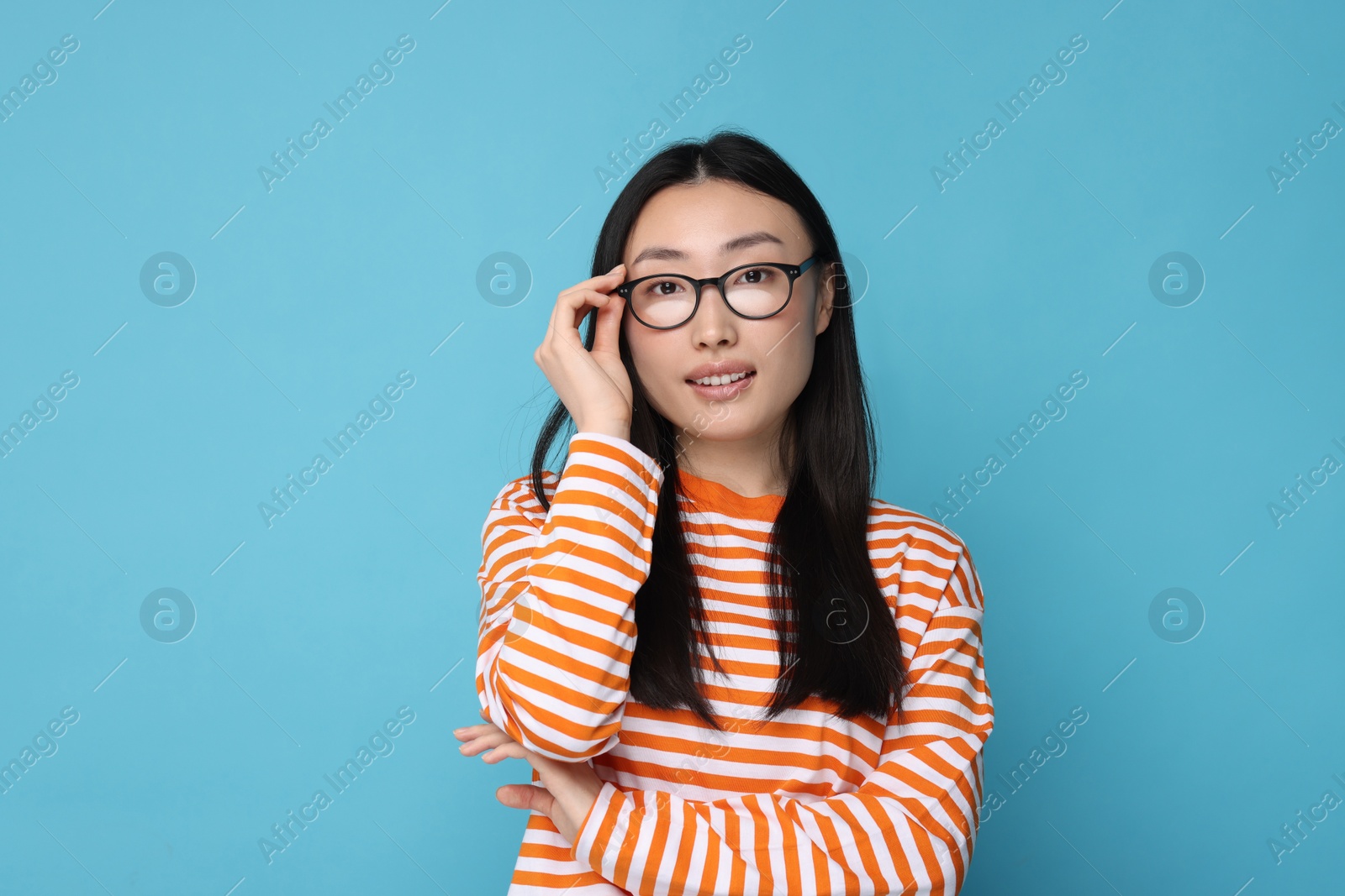 Photo of Portrait of happy woman in glasses on light blue background