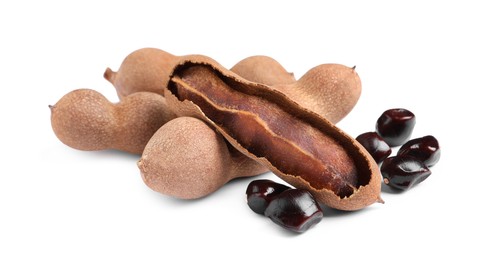 Delicious ripe tamarinds and seeds on white background. Exotic fruit