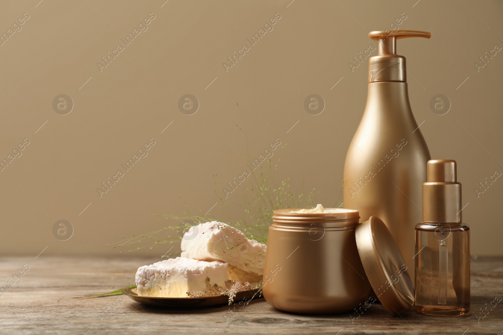 Photo of Set of hair cosmetic products on wooden table. Space for text