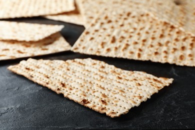 Photo of Traditional matzos on black table, closeup view