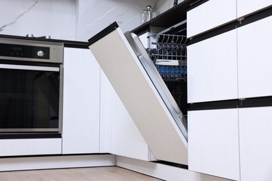 Built-in dishwasher with open door in kitchen, low angle view