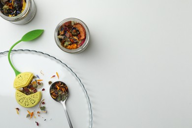 Photo of Different dry herbs and tea on white background, flat lay. Space for text