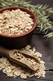 Photo of Bowl and scoop with oatmeal on wooden table, closeup