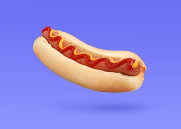 Image of Yummy hot dog with ketchup and mustard in air against blue violet background