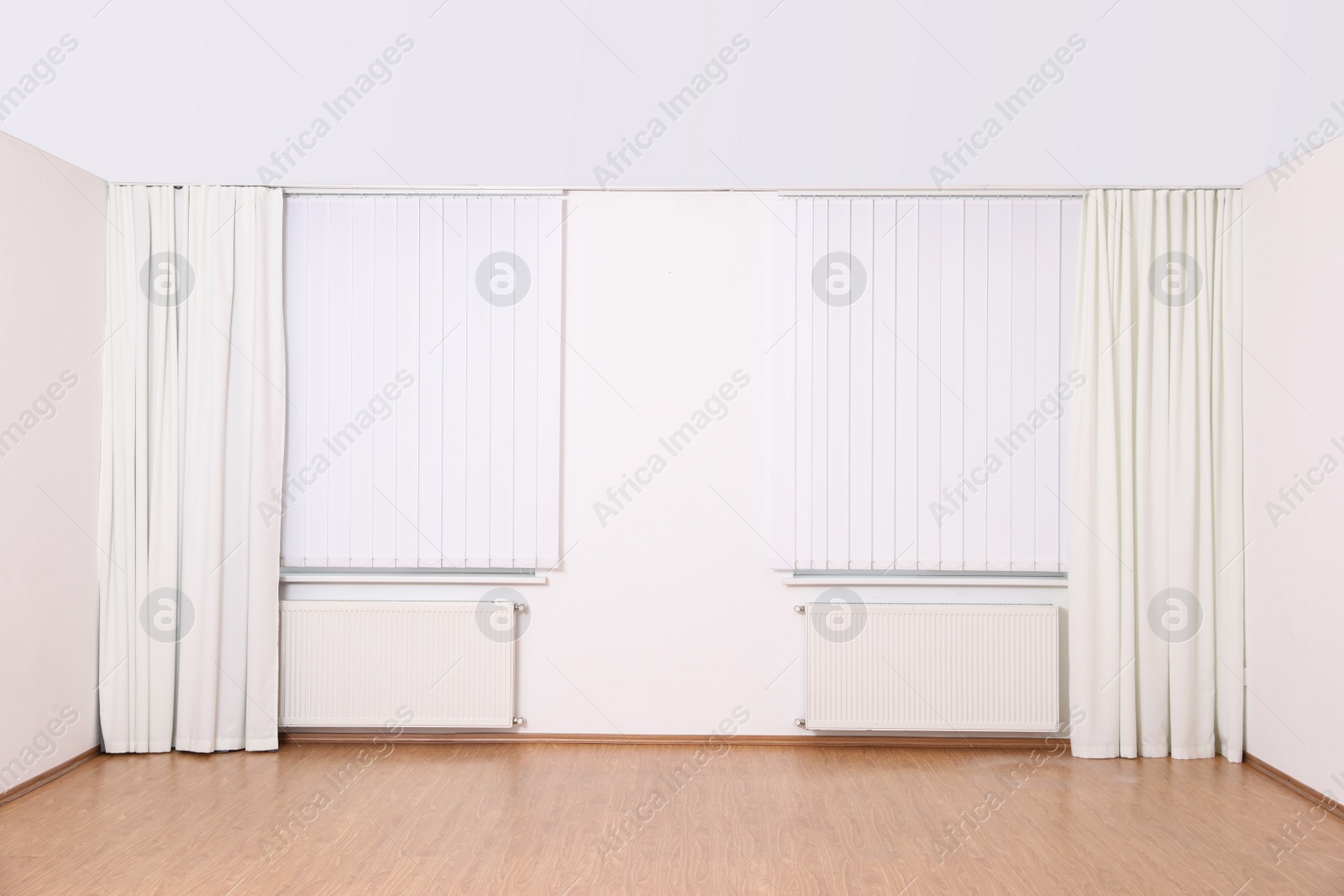 Photo of Windows with elegant curtains and blinds in empty room