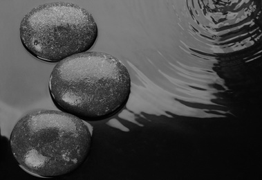 Photo of Spa stones in water, top view with space for text. Zen lifestyle