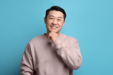 Photo of Portrait of happy man on light blue background