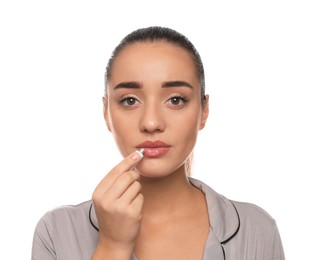 Photo of Woman with herpes applying cream on lips against white background