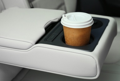 Takeaway paper coffee cup in holder inside car