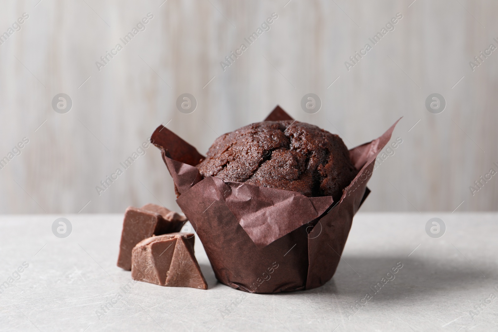 Photo of Tasty chocolate muffin on grey table, closeup