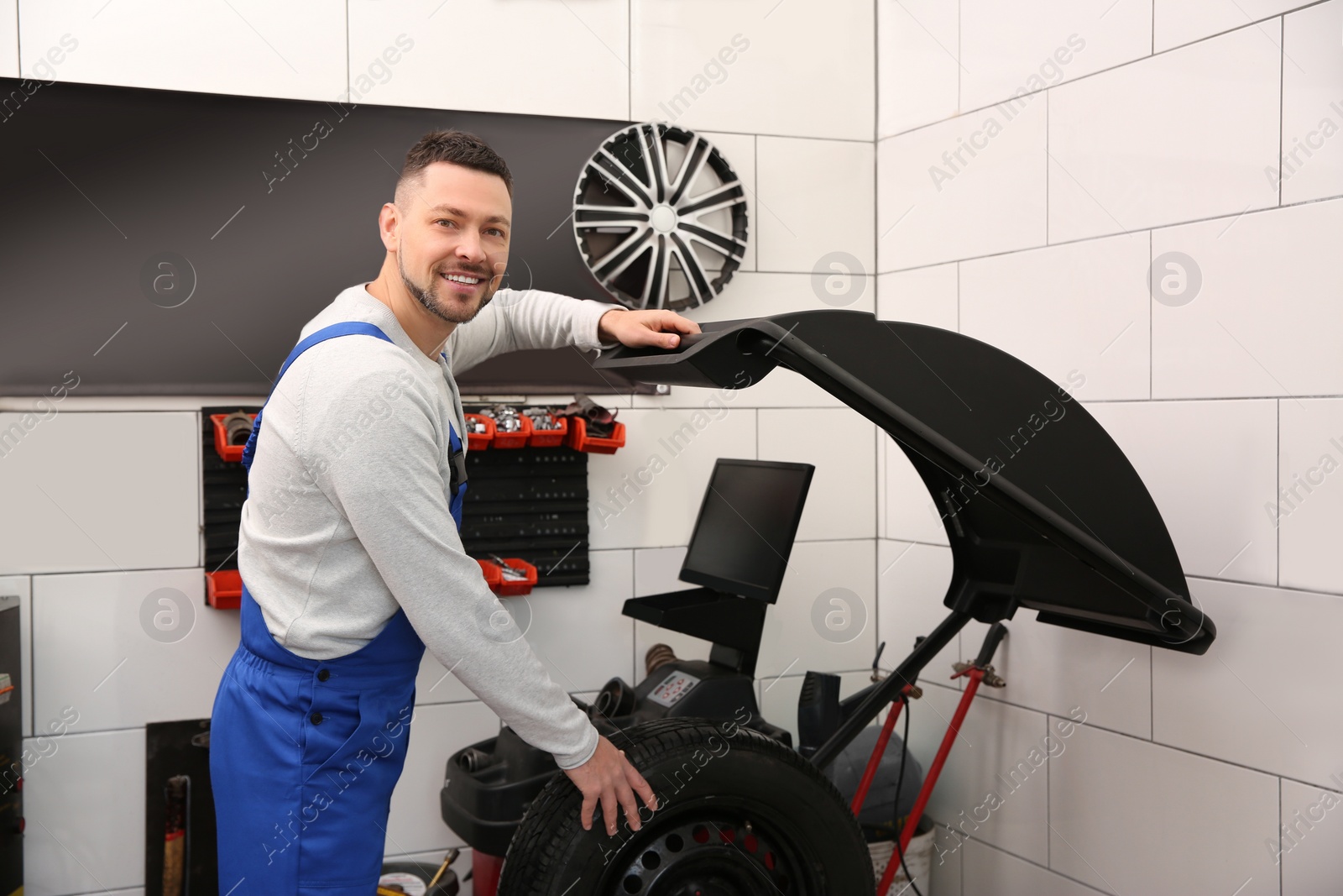 Photo of Mechanic working with wheel balancing machine at tire service