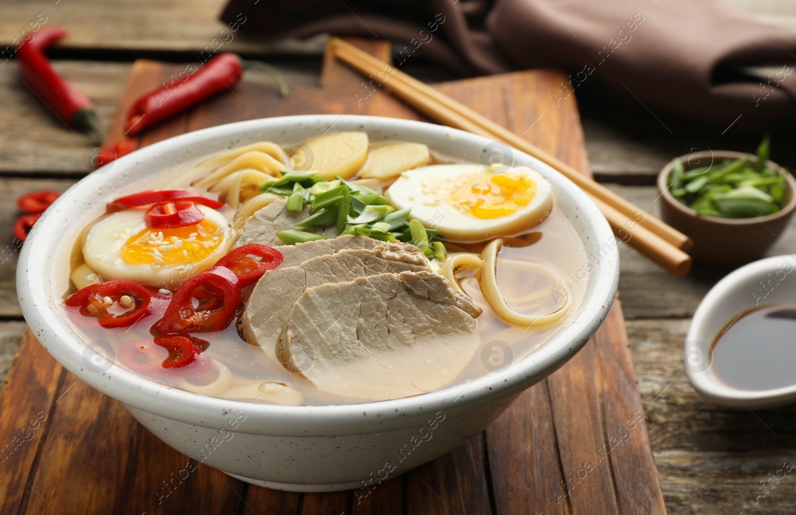 Photo of Delicious ramen in bowl on wooden table, closeup. Noodle soup