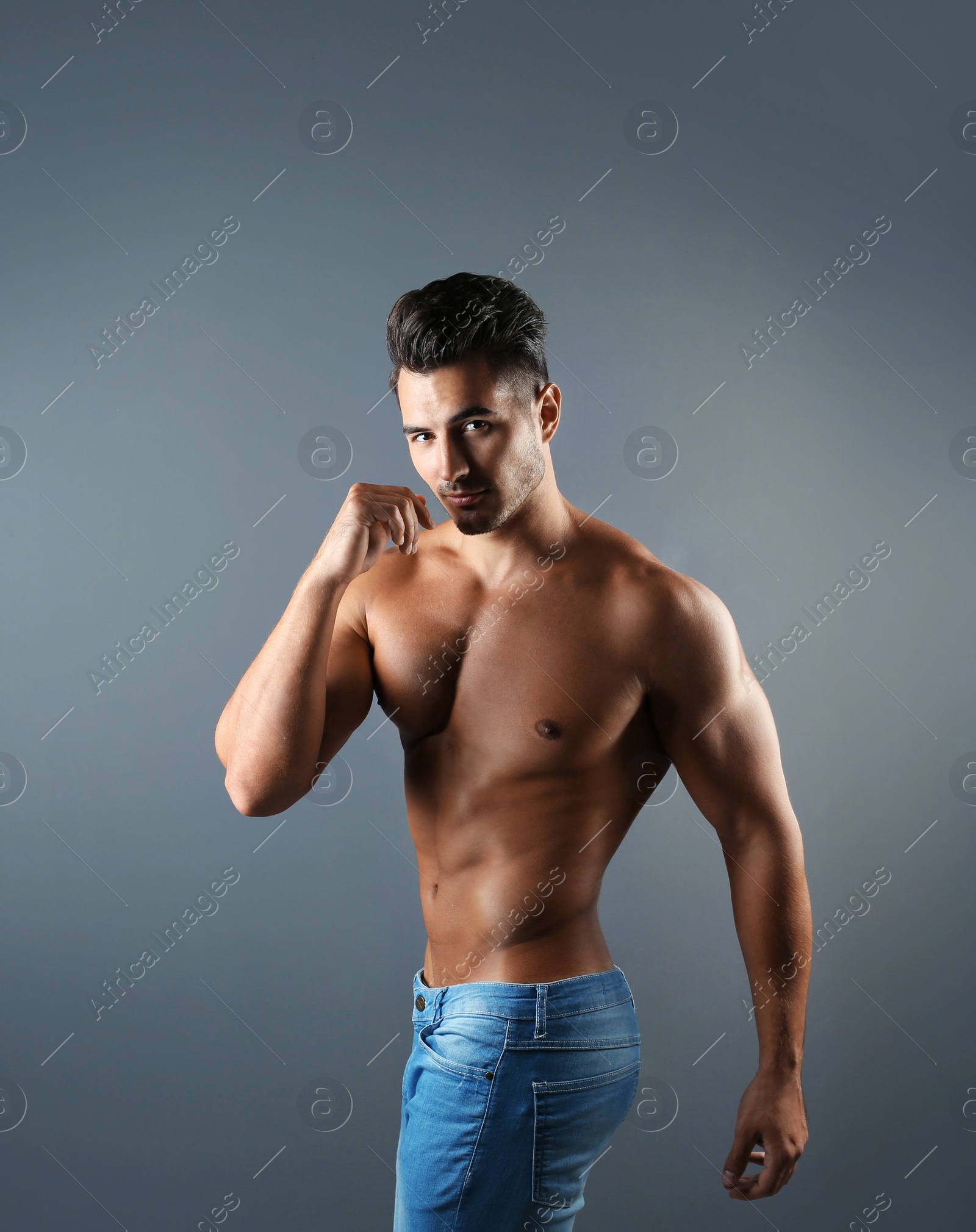 Photo of Shirtless young man in stylish jeans on grey background