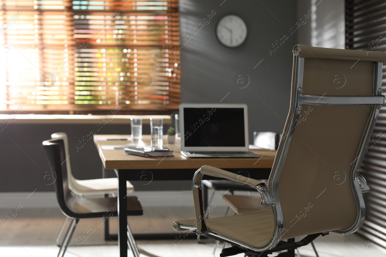 Photo of Laptop on wooden table in modern office