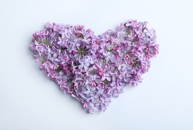 Photo of Heart made of blossoming lilac on light background, flat lay. Spring flowers