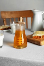 Delicious honey, milk and bread with butter served for breakfast on table indoors
