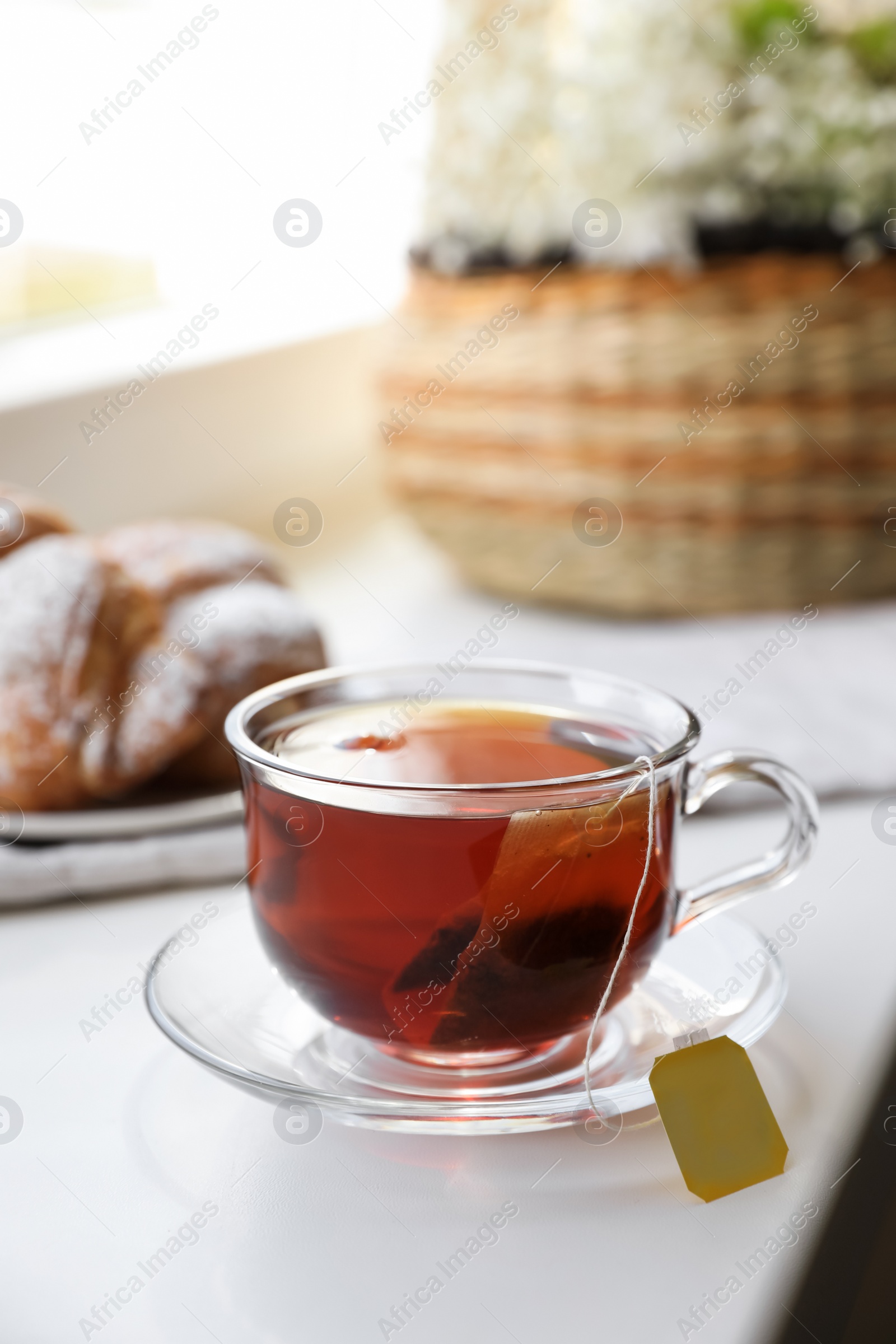 Photo of Tea bag in glass cup on white windowsill
