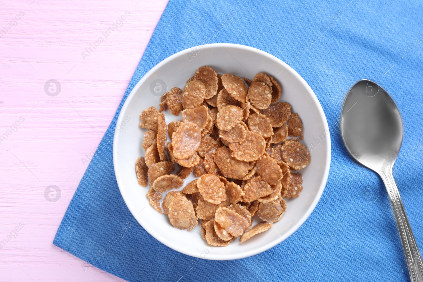 Photo of Cornflakes with milk on pink wooden table, flat lay. Healthy breakfast