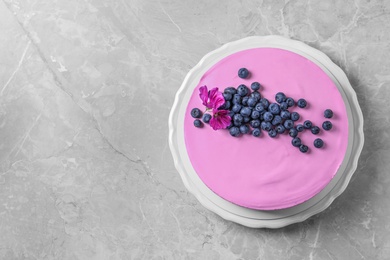 Photo of Plate with tasty blueberry cake on light grey table, top view. Space for text