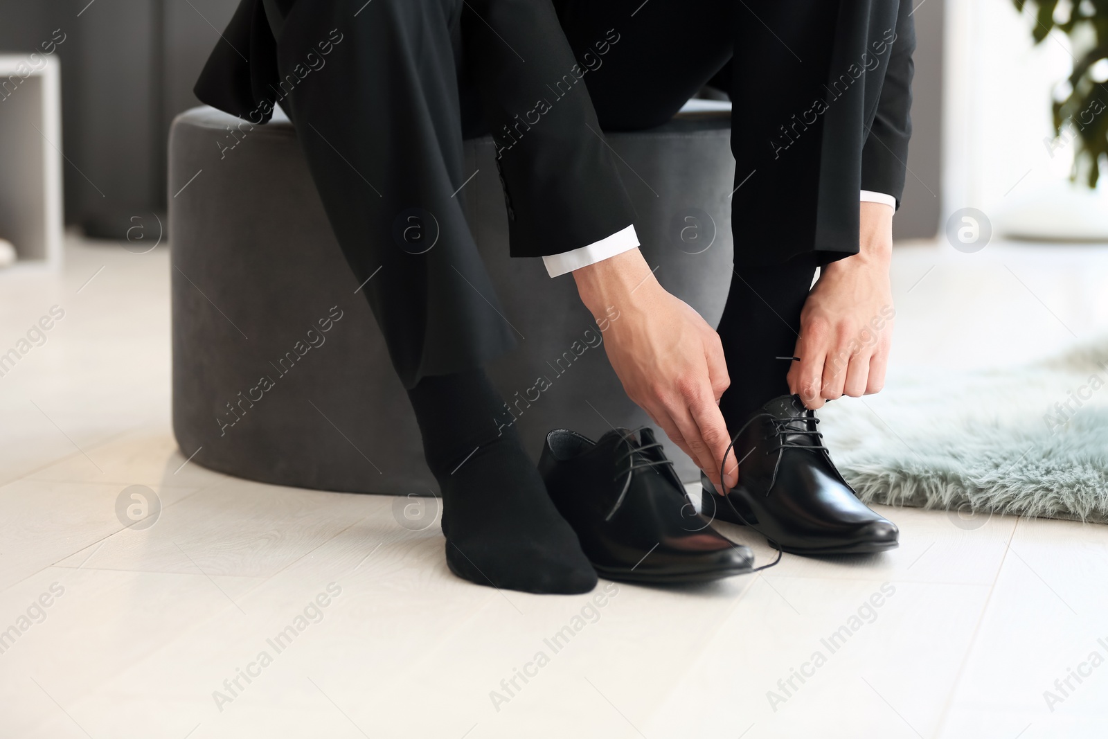 Photo of Young man trying on shoes in store